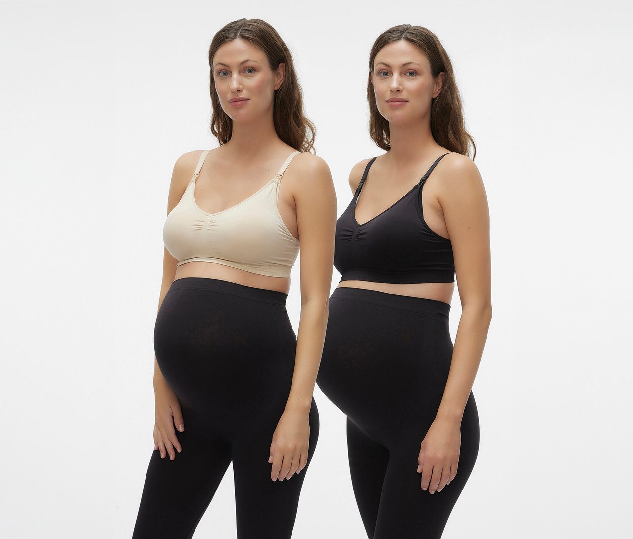 Dvě těhotné ženy nosí MAMALICIOUS MLILJA FEED ME BRA 2-P NOOS a černé legíny na bílém pozadí.