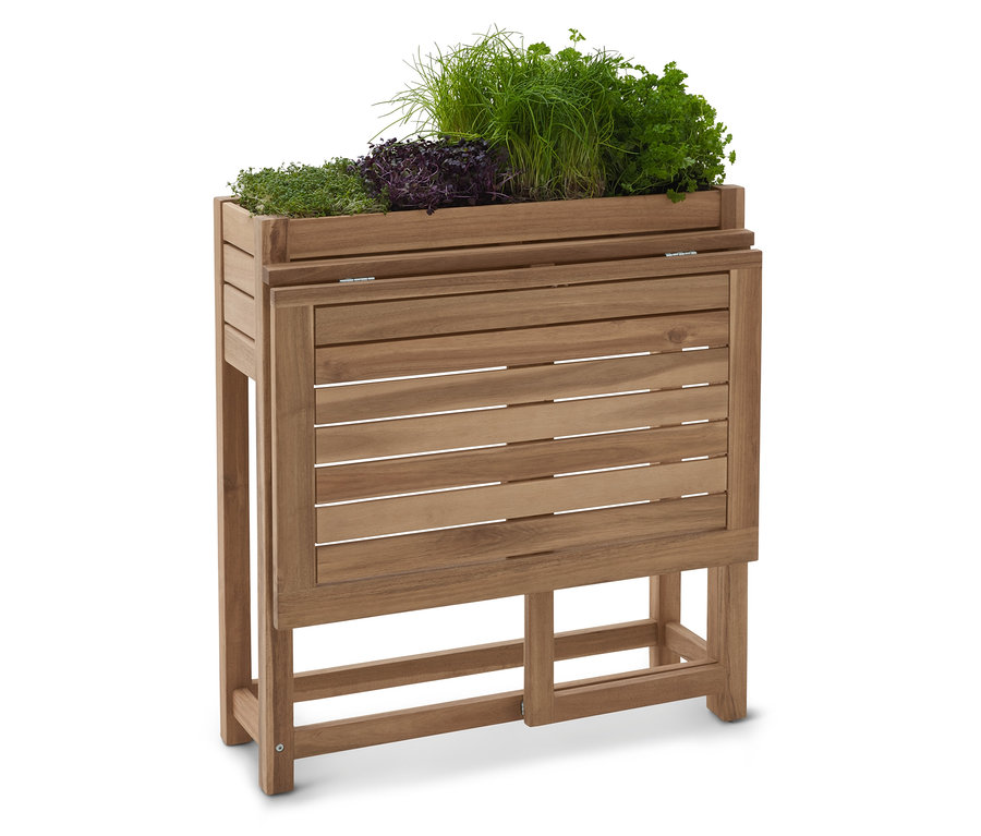 Dřevěný vyvýšený záhon s různými bylinkami.