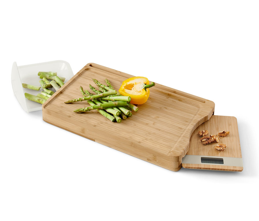 Bambusové krájecí prkénko s vyjímatelnou kuchyňskou váhou, žlutou paprikou a chřestem.