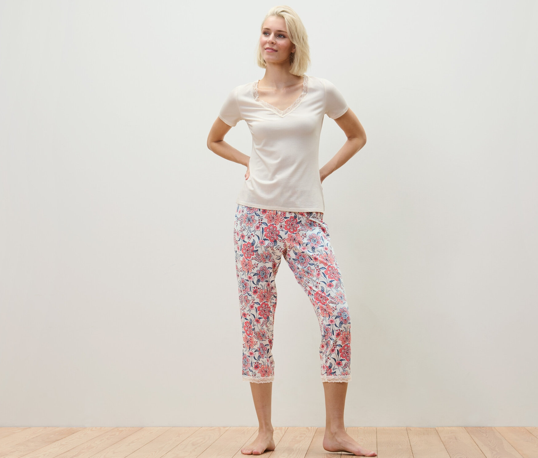 Žena pózuje v pyžamu s celoplošným potiskem.