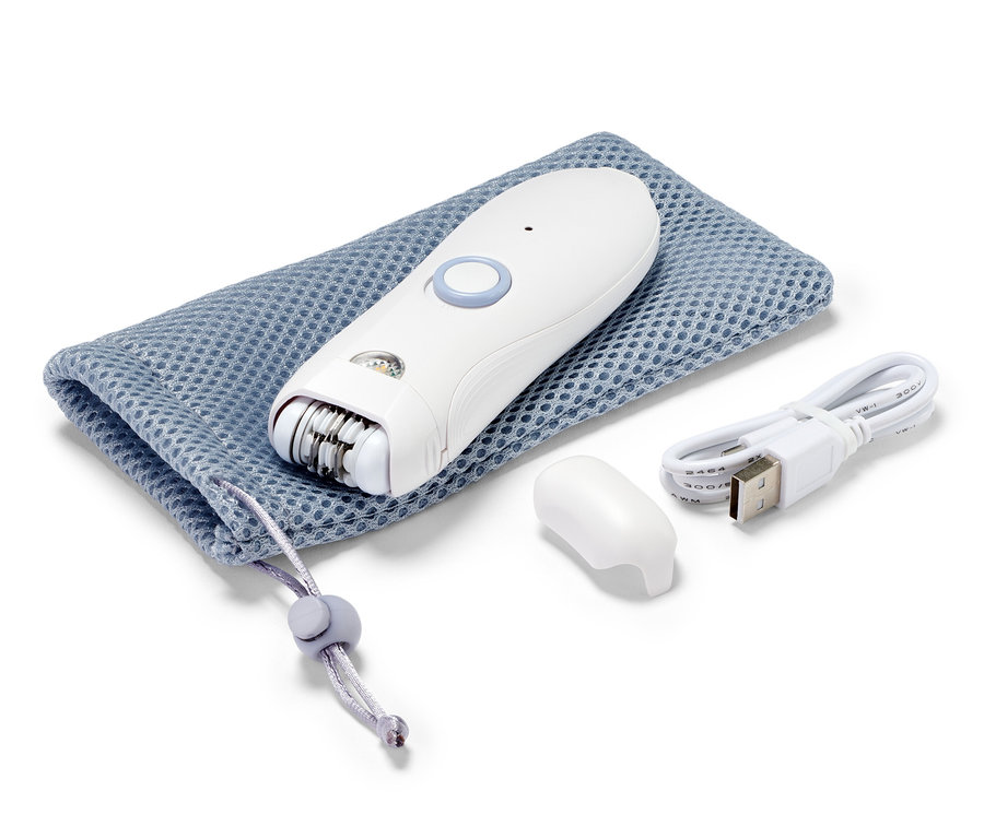 Bílý epilátor na obličej leží na modrém pouzdře se stahovací šňůrkou vedle nabíjecího kabelu a krytky.
