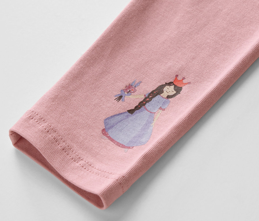 Detail růžových dětských legín s potiskem princezny.