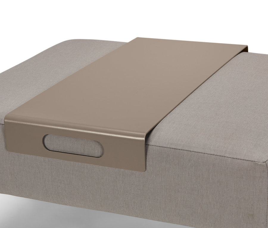 Detail venkovní pohovky se stoličkou a stříbrným podnosem.