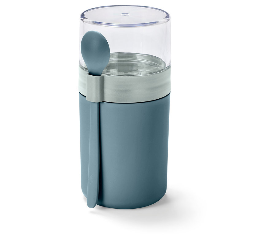 Zelený kelímek na jogurt na cesty se lžičkou.