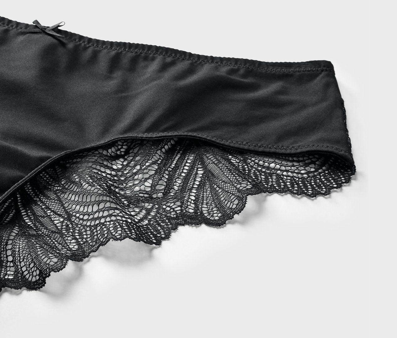 Detail černých brazilských kalhotek s krajkou.