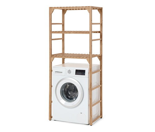 Bílá sušička stojí pod regálem na pračku z masivního dřeva.