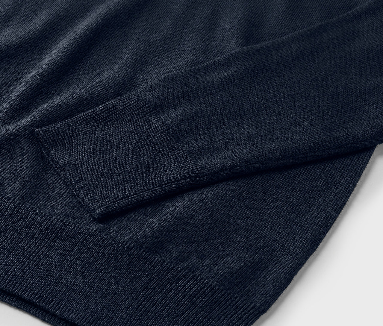 Detailní záběr na tmavě modrý merino-pletený svetr.