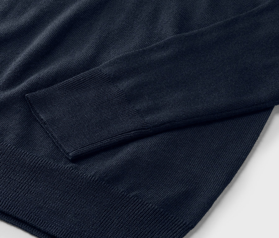 Detailní záběr na tmavě modrý merino-pletený svetr.