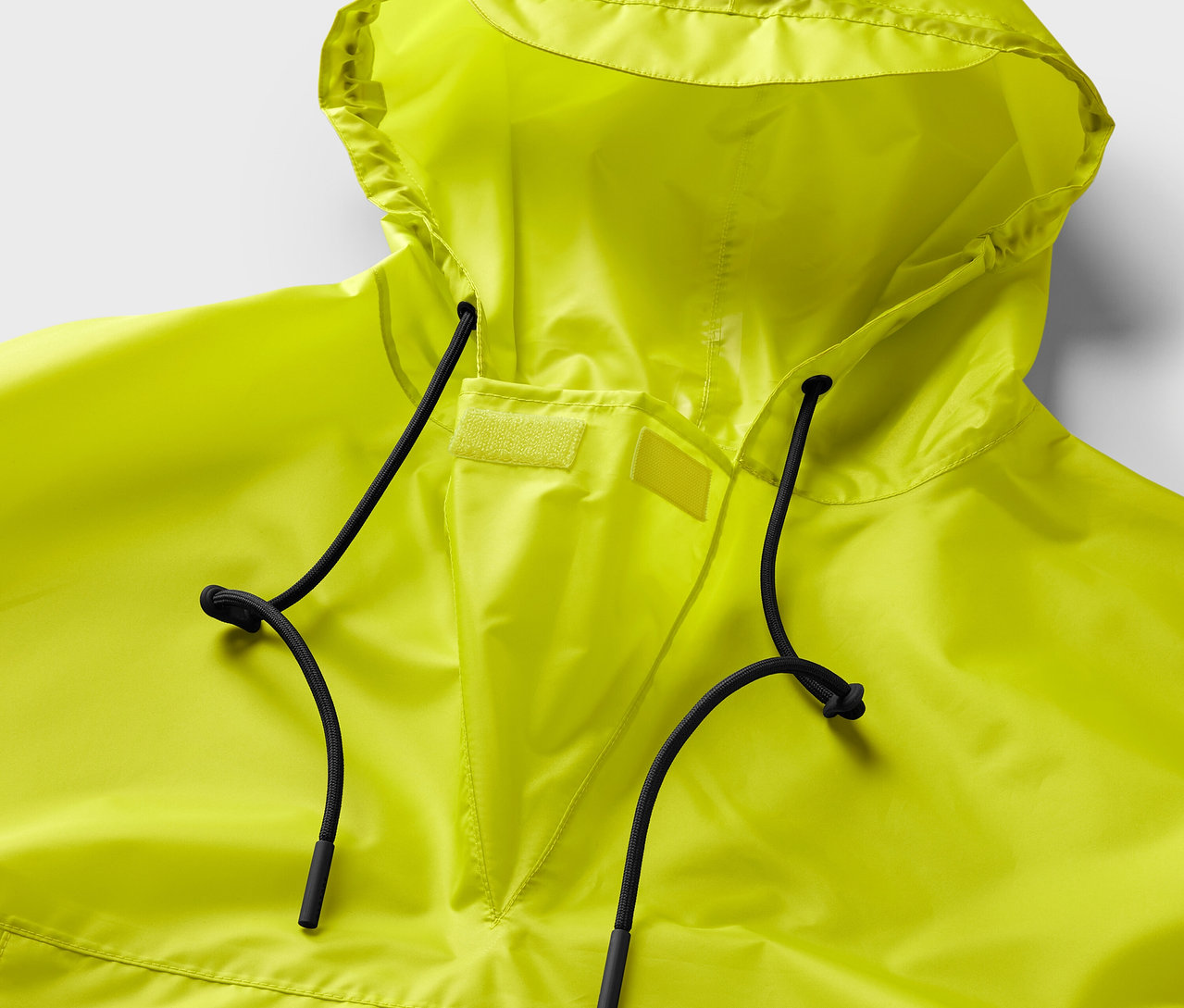 Žluté pončo do deště s kapucí a černými stahovacími šňůrkami.