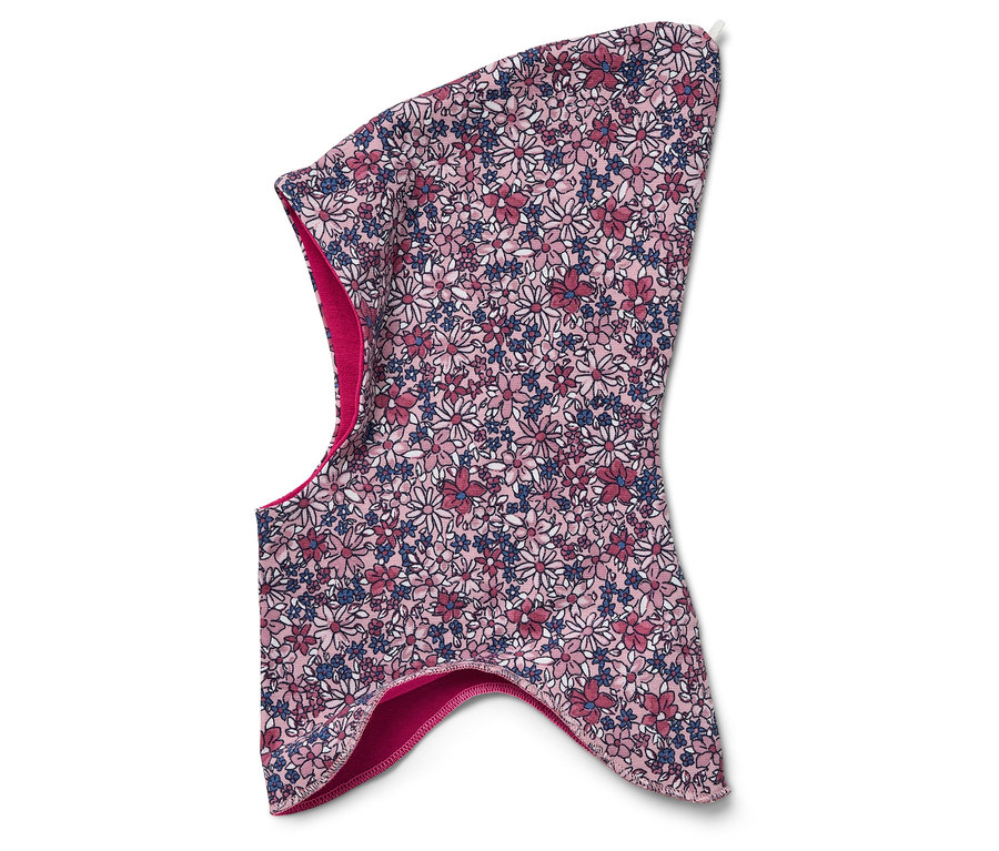 Detail dětské kukly s květinovým vzorem na bílém pozadí.