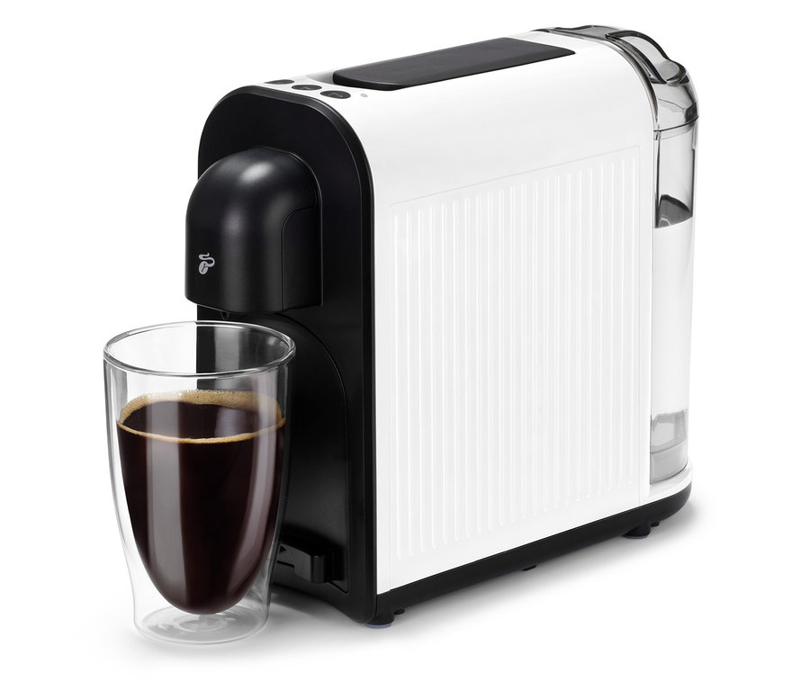Bílý kávovar Cafissimo now white se sklenicí kávy před ním.