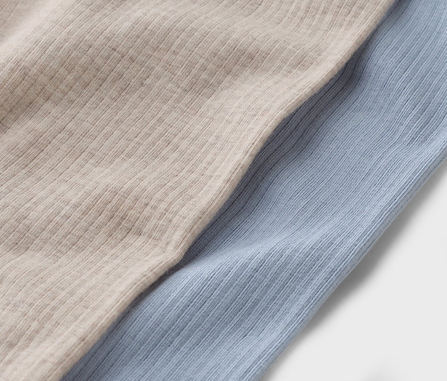 Detail dvou kusů látky: béžové a světle modré.