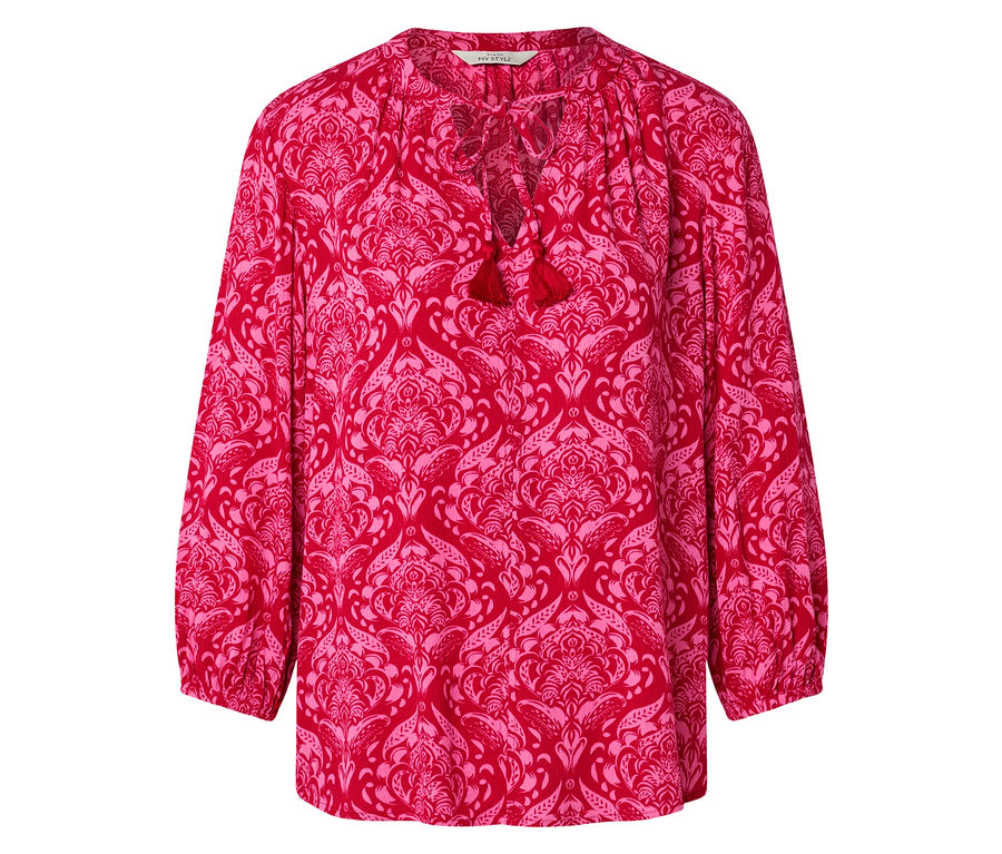 Červená halenka s růžovým květinovým vzorem a střapci na výstřihu.