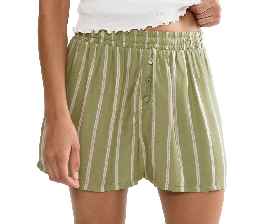 Žena má na sobě pruhované šortky se zapínáním na knoflíky.