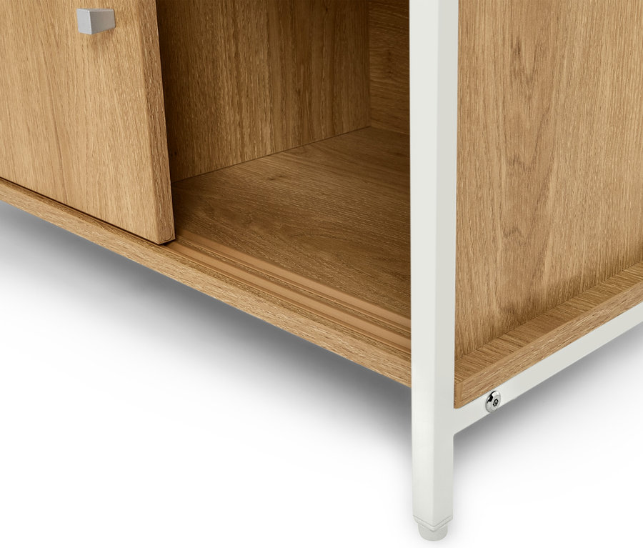 Detailní pohled na světle hnědou dřevěnou skříňku s bílými nohami.