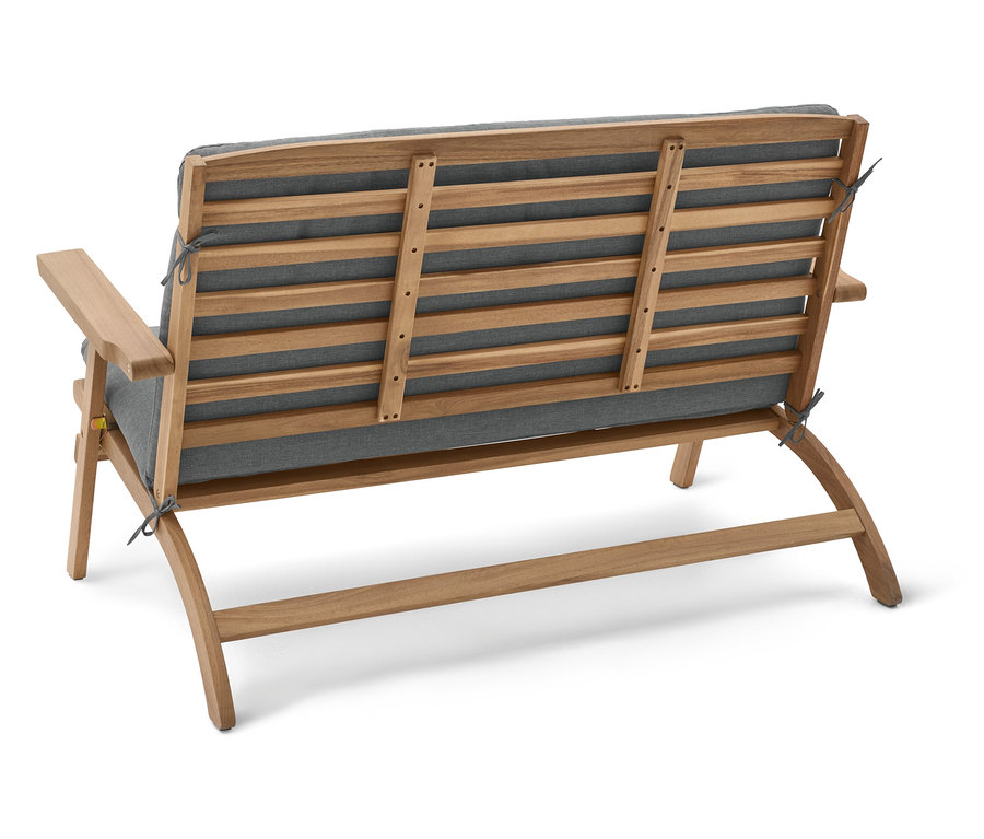 Pohled zezadu na dřevěnou zahradní lavici se šedými polštáři.