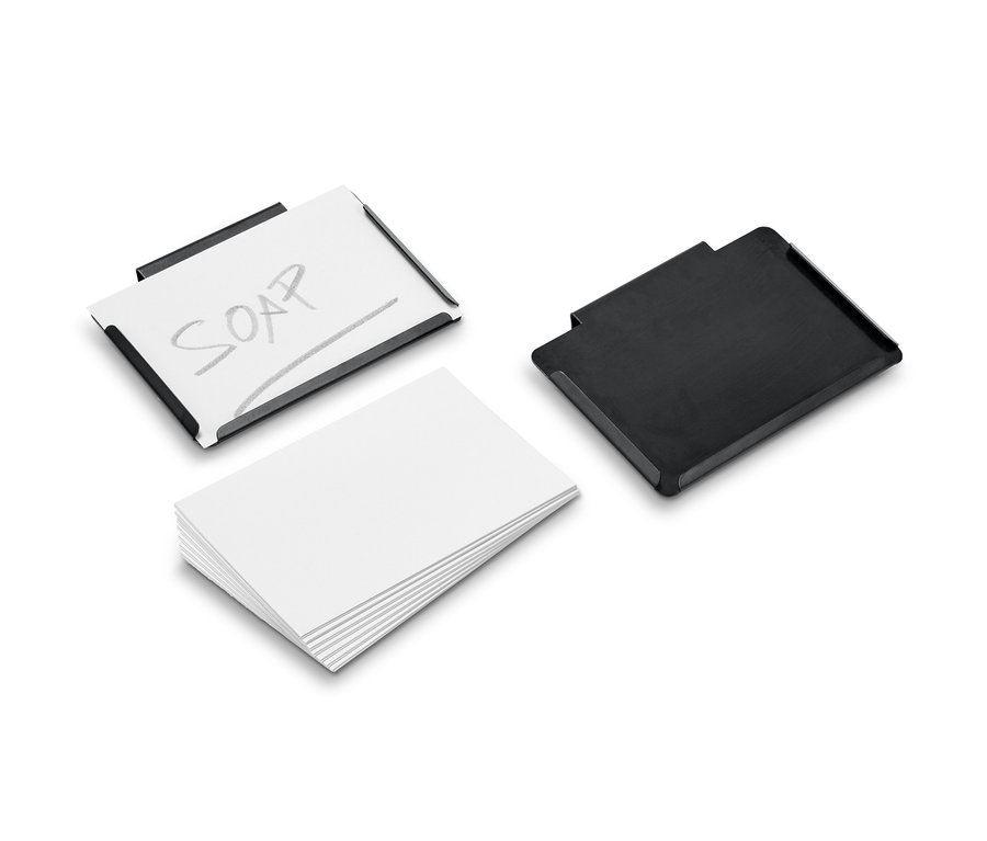 Dva kovové klipy, jeden s papírem a nápisem SOAP, druhý černý, vedle sebe leží stoh bílých papírů.