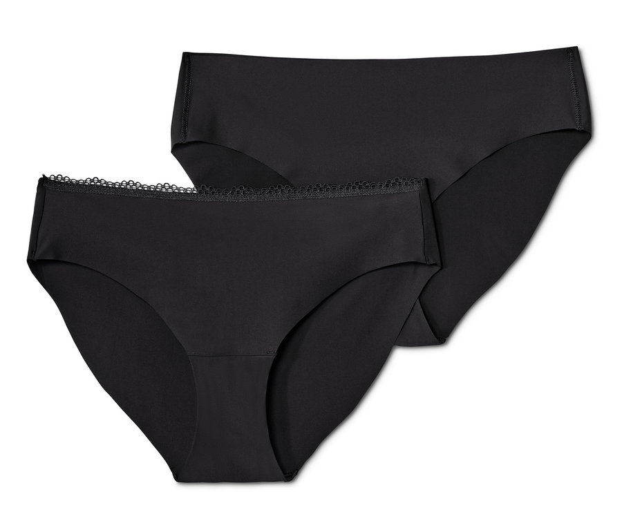 Dvoje černé kalhotky »Magic Cut« na sobě.