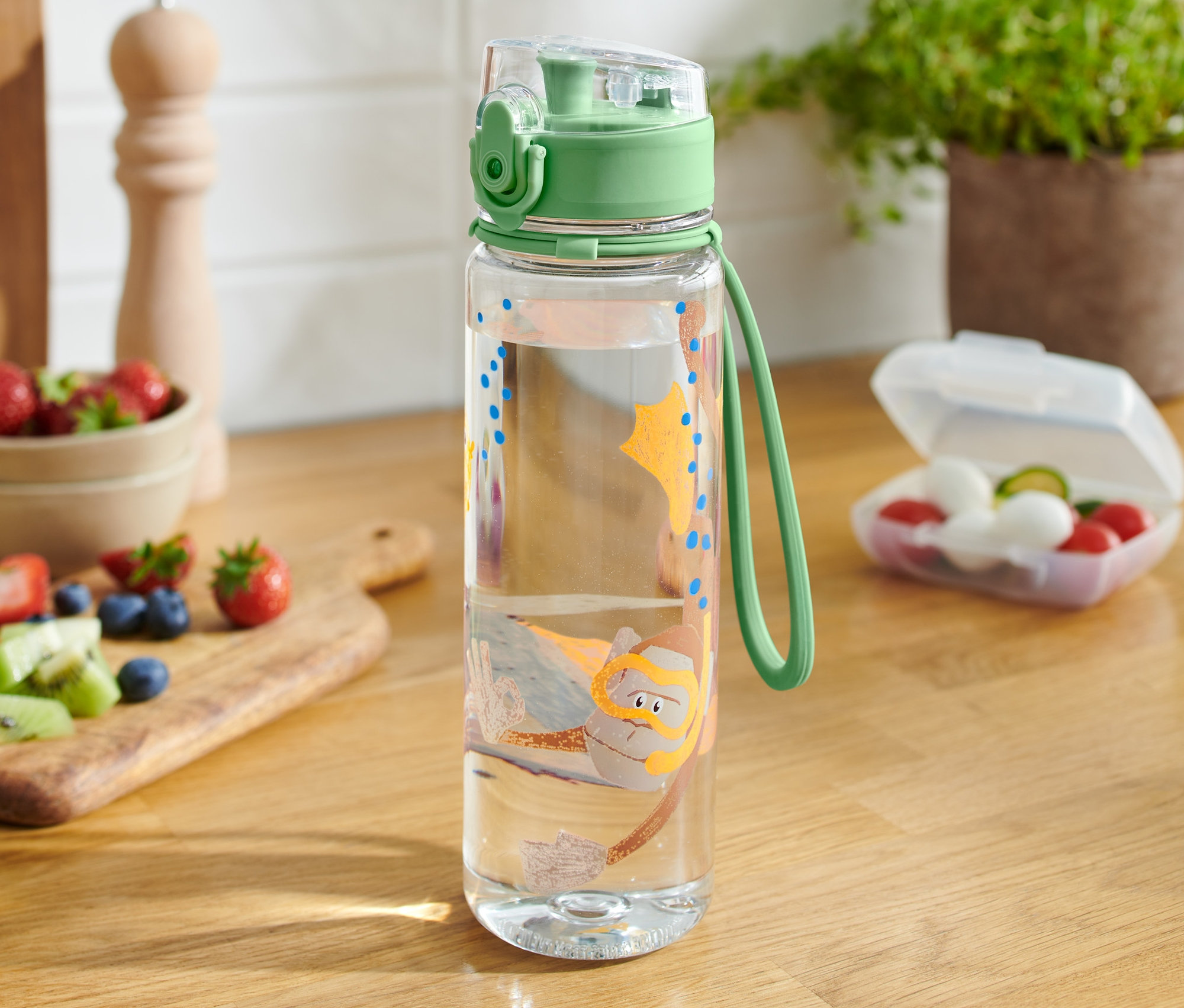 Průhledná láhev na pití s obrázkem potápěče na dřevěném stole.