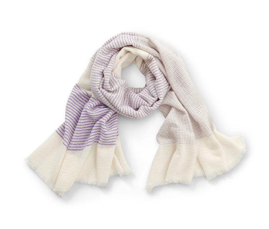 Tkaná šála s proužky je stočená na bílém pozadí.