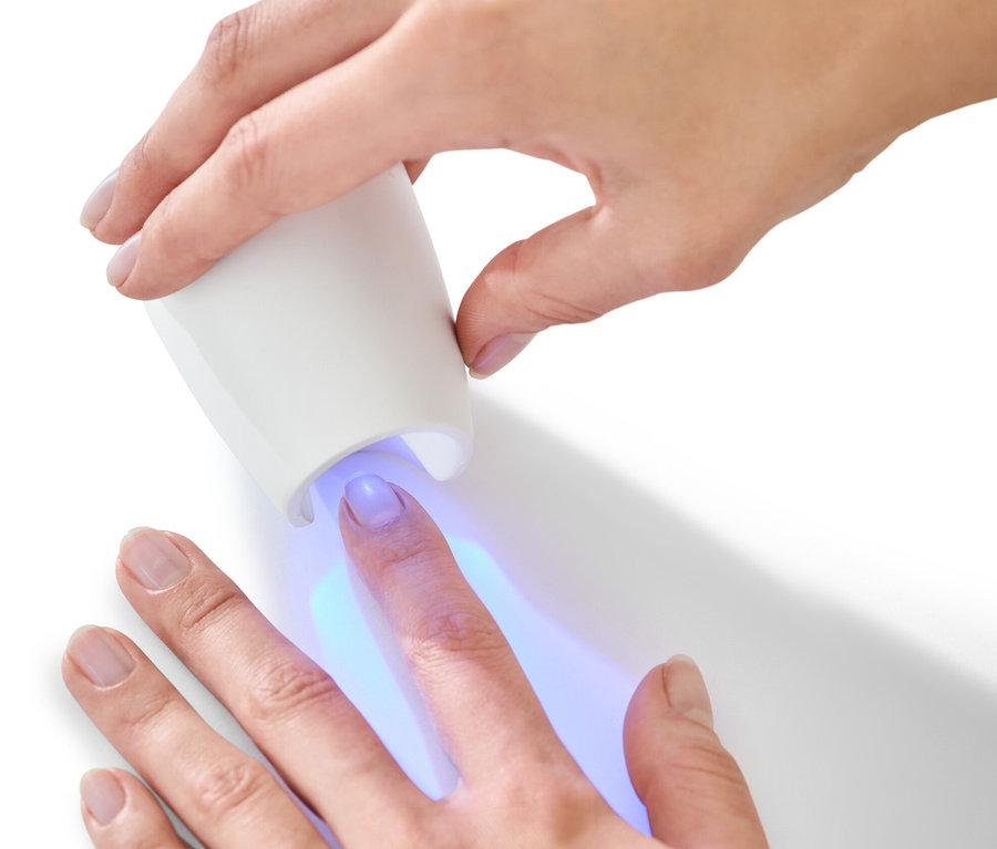 Žena používá UV lampu ze sady na manikúru a pedikúru 5 v 1.