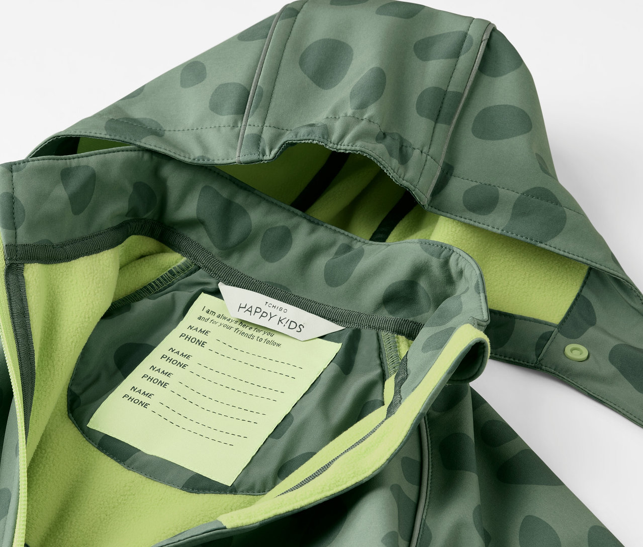 Detail dětské softshellové kombinézy s kapucí a štítkem na jméno.
