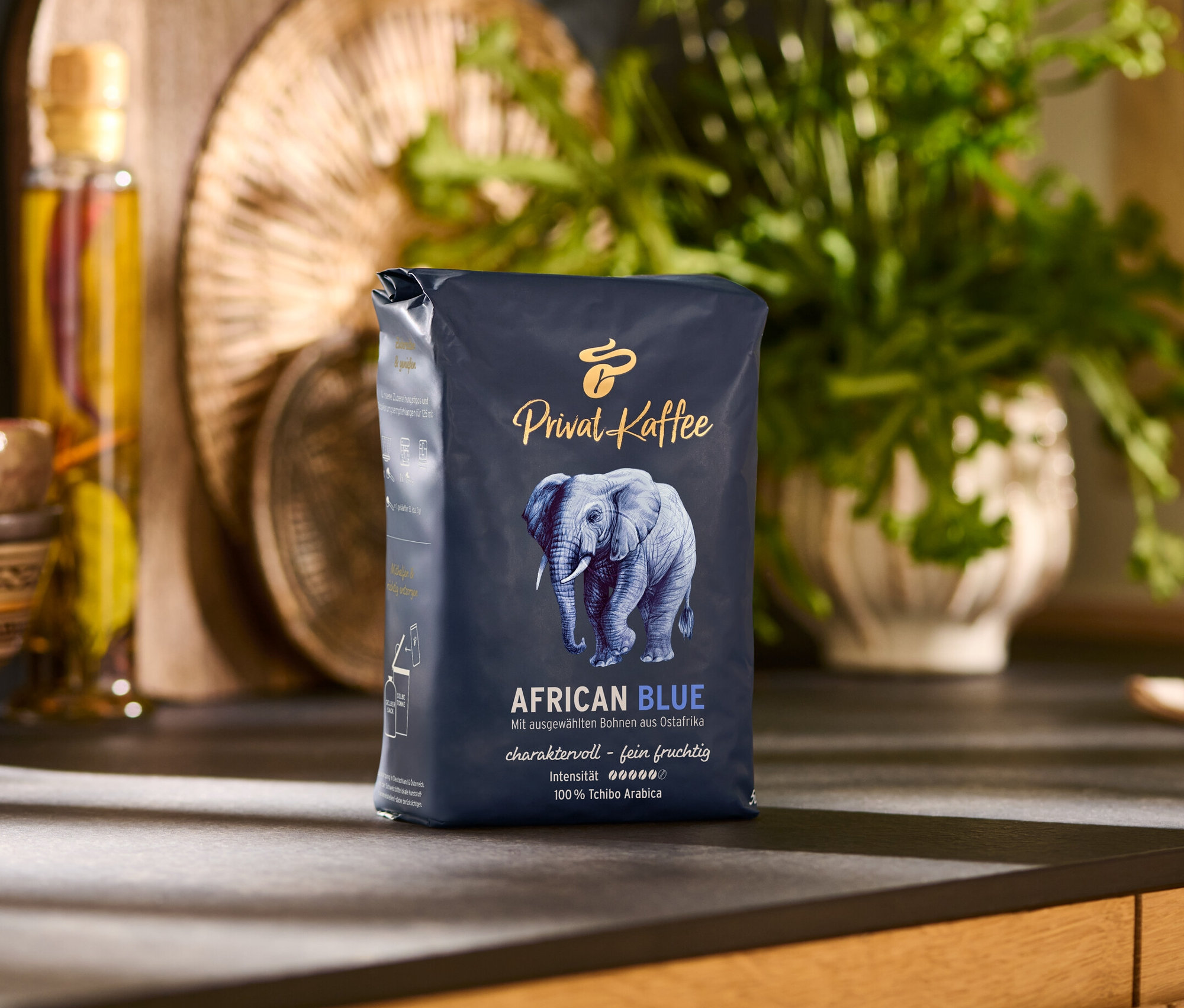 Balení zrnkové kávy Privat Kaffee African Blue 500 g na kuchyňské lince.