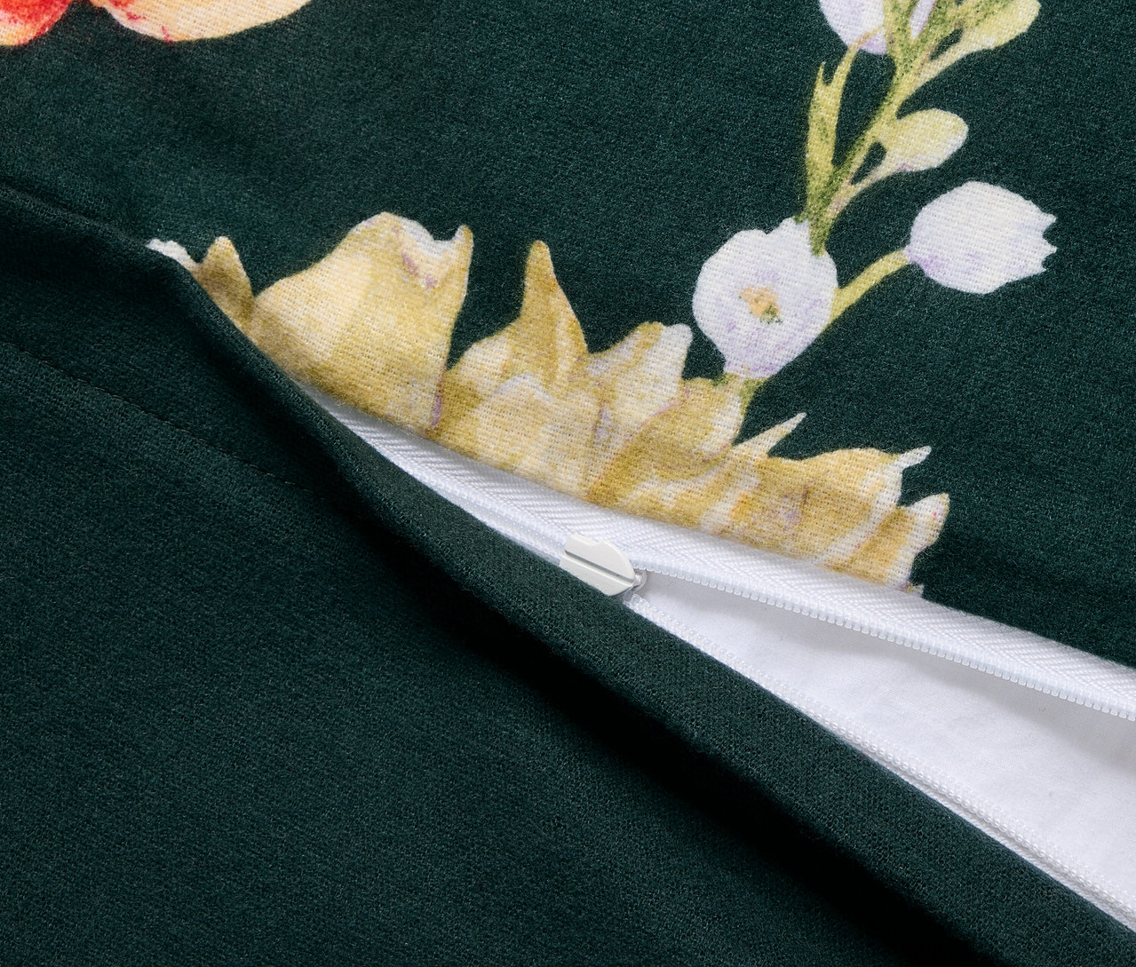 Detailní záběr na zelené flanelové povlečení standardní velikosti s květinovým vzorem a zipem.