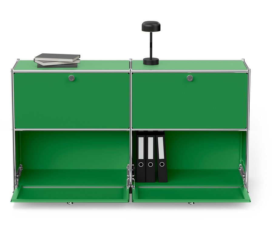 Zelená modulární skříňka se stříbrným rámem, nahoře lampa a knihy, dole tři černé pořadače.