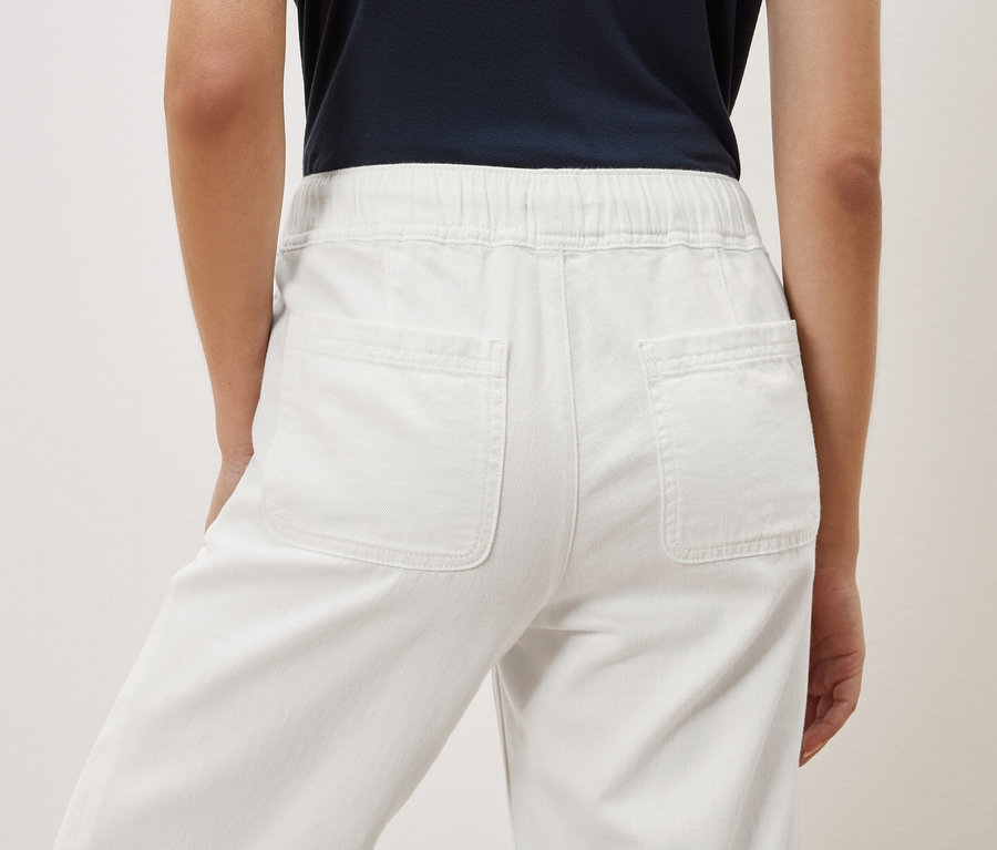 Zezadu je vidět žena v bílých kalhotách.