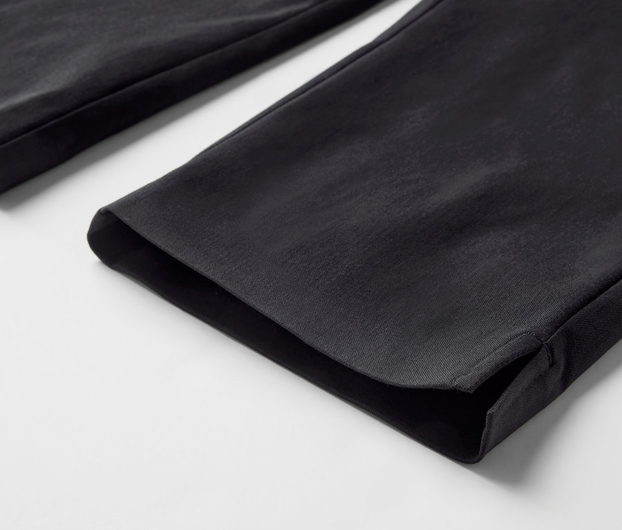 Detailní záběr na černé 3/4 strečové kalhoty.