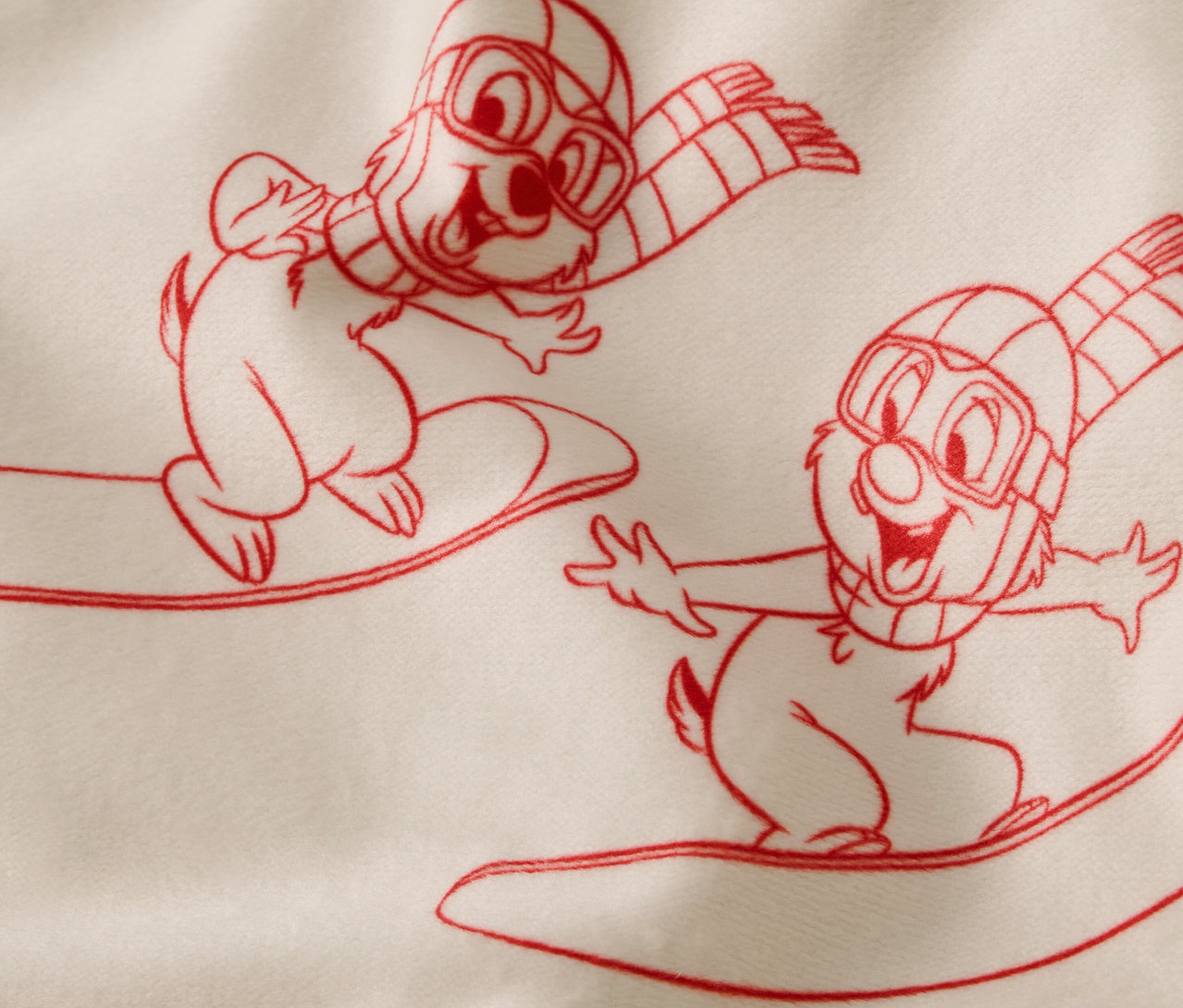 Kreslená ilustrace dvou veverek na snowboardech s lyžařskými brýlemi a šálami.