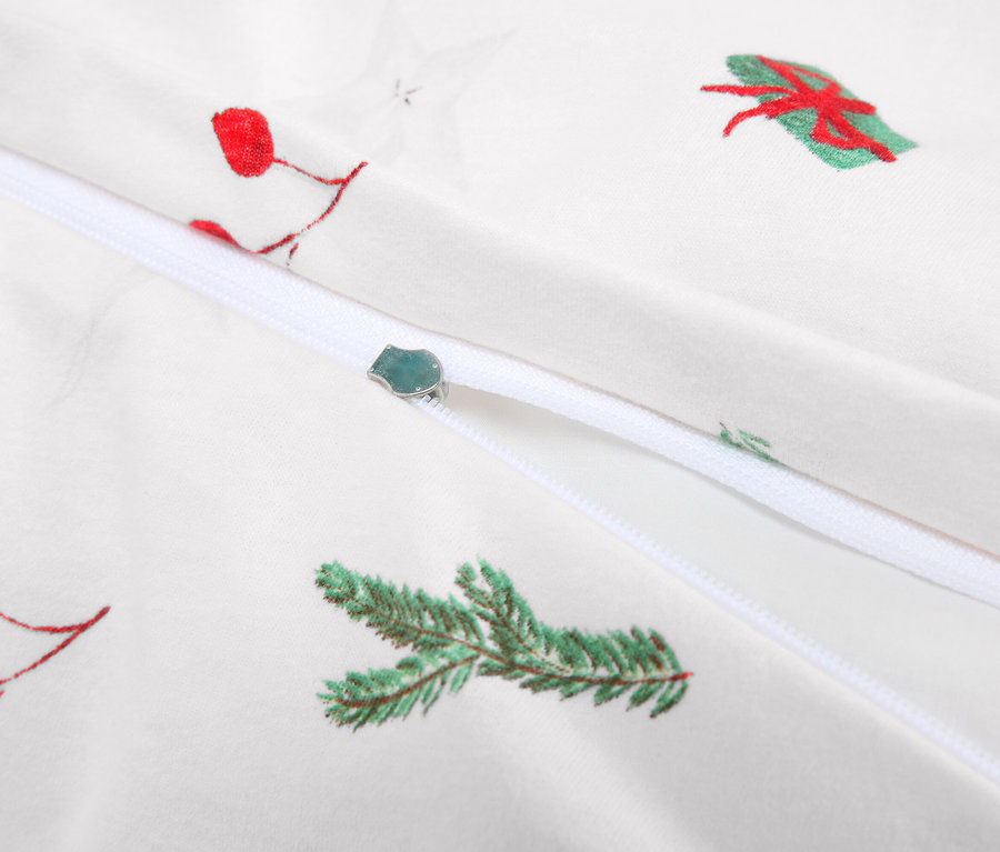 Detail bílého povlečení se zipem a vánočními motivy.