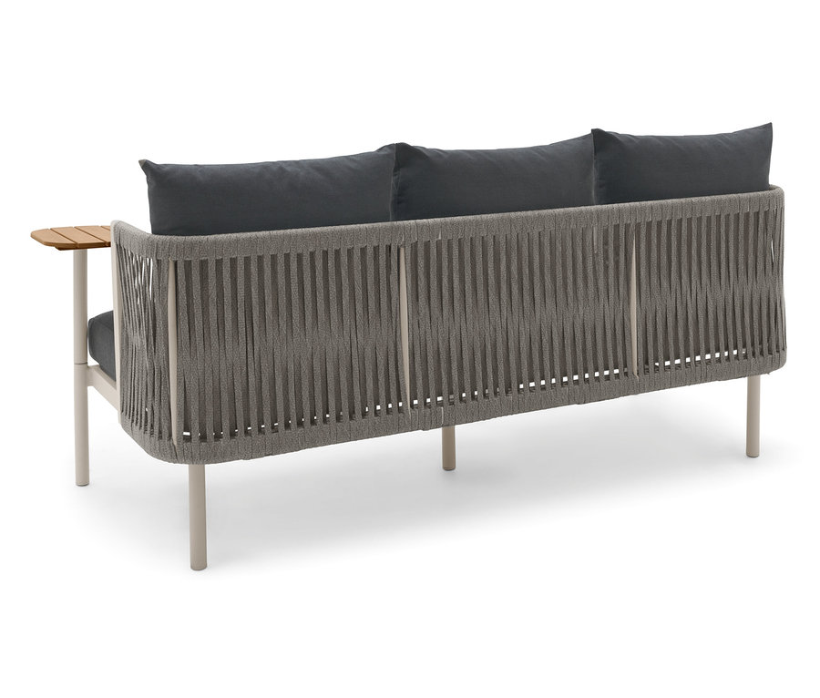 Pohled zezadu na zahradní pohovku se dvěma otočnými stolky a šedými polštáři.