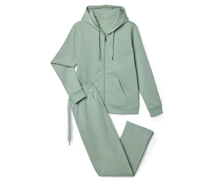 Světle zelená tepláková souprava skládající se z mikiny na zip s kapucí a tepláků leží na bílém pozadí.