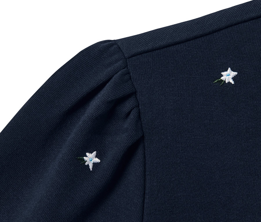 Detail tmave modre mikiny s vysivkami kvetin.