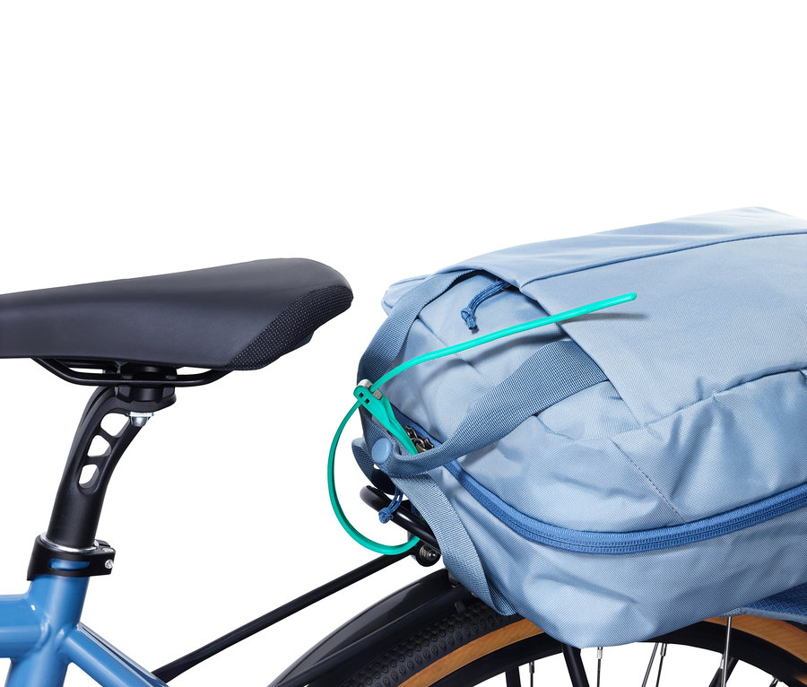 Modré kolo s káblovým zámkem, který zajišťuje modrou tašku na kole.