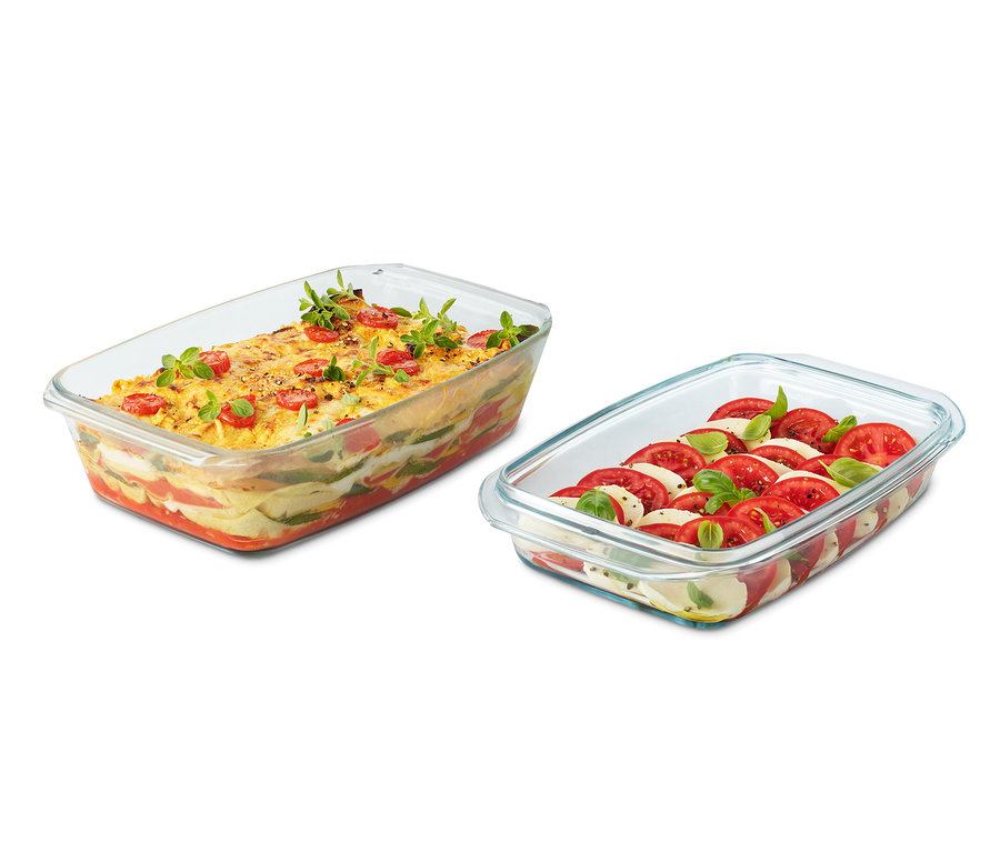 Dvě skleněné zapékací mísy. Jedna se zapečenou zeleninou a rajčaty. Druhá s rajčaty, mozzarellou a bazalkou.