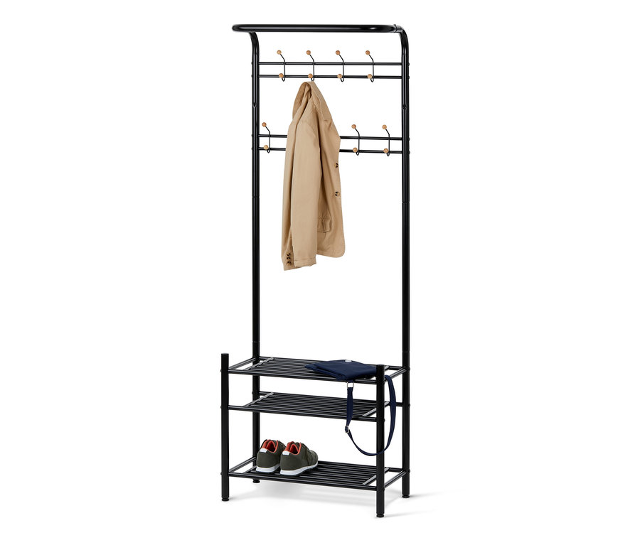 Černý věšák na šaty s přihrádkou na boty, na kterém visí béžový kabát a leží modrá taška a zelené boty.