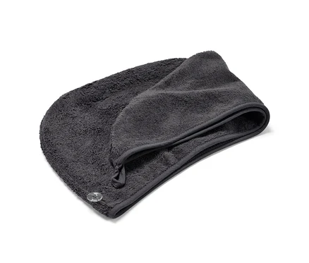 Antracitový ručníkový turban leží složený na bílém pozadí.