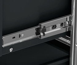 Detail výsuvu zásuvky u černého kovového nábytku.