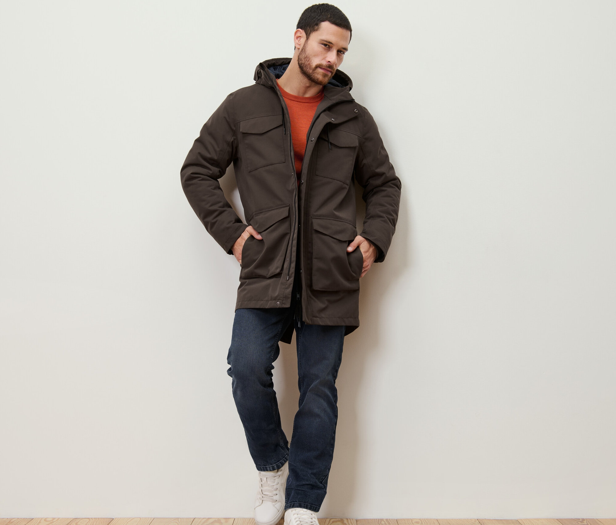 Muž opřený o zeď má na sobě parku.