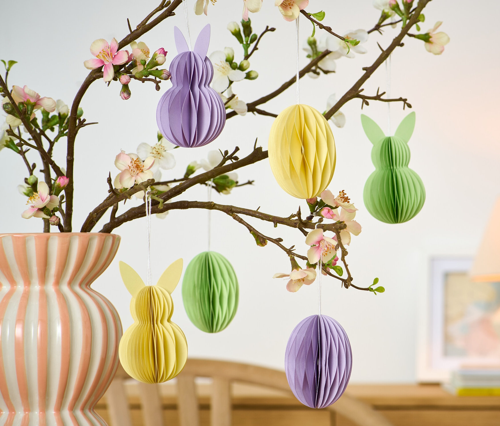 Kvetoucí větev ve váze s papírovými velikonočními ozdobami, 6 ks, ve tvaru vajíček a zajíčků.