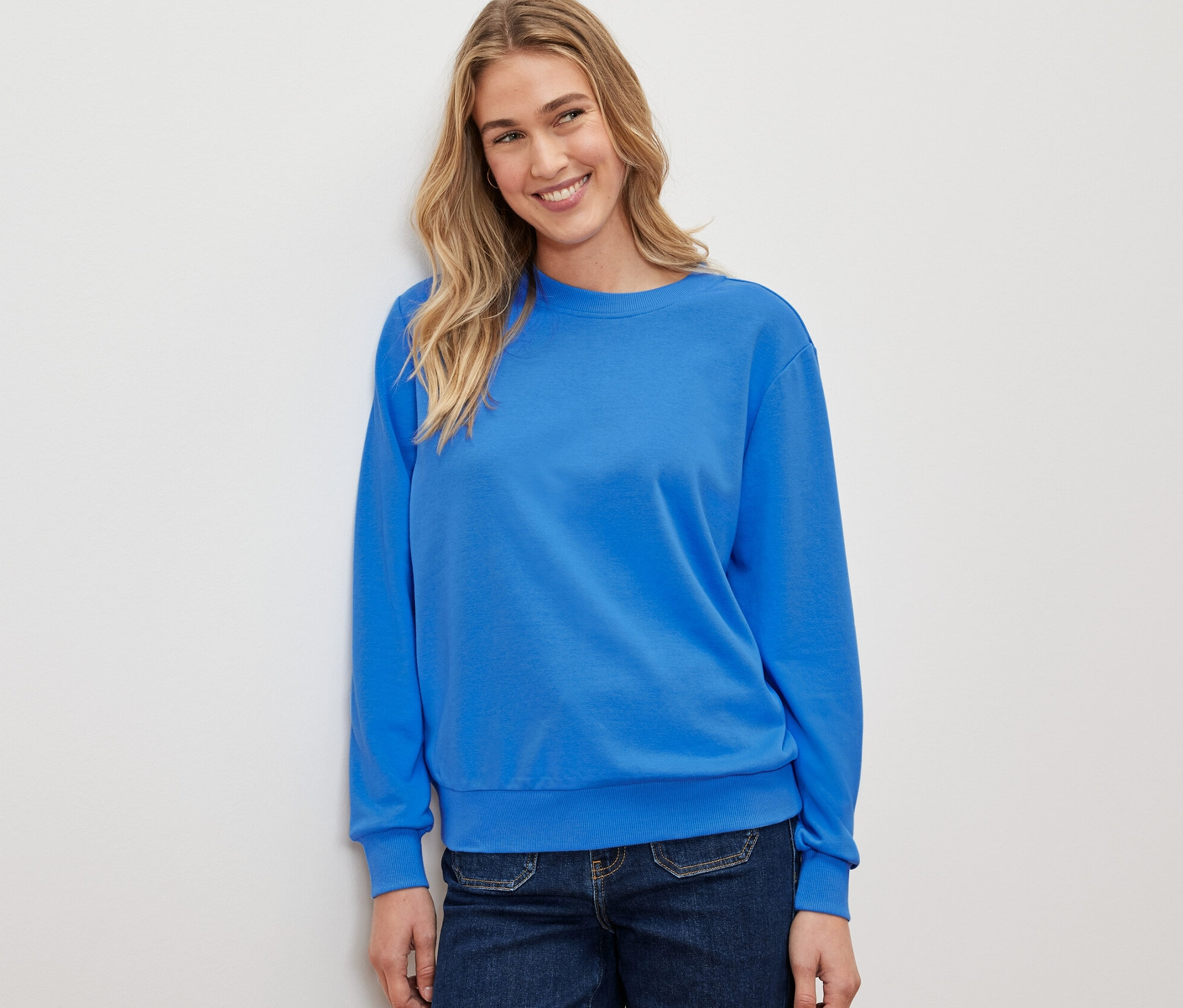 Žena má na sobě kobaltově modrou mikinu.