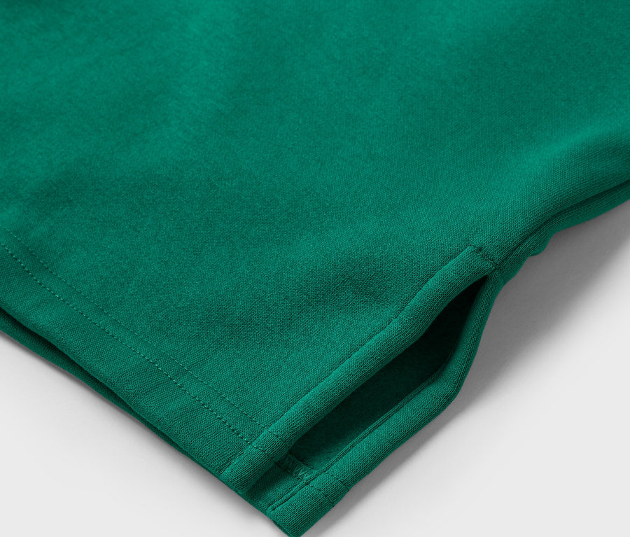 Detail zeleného trička s kapsou.