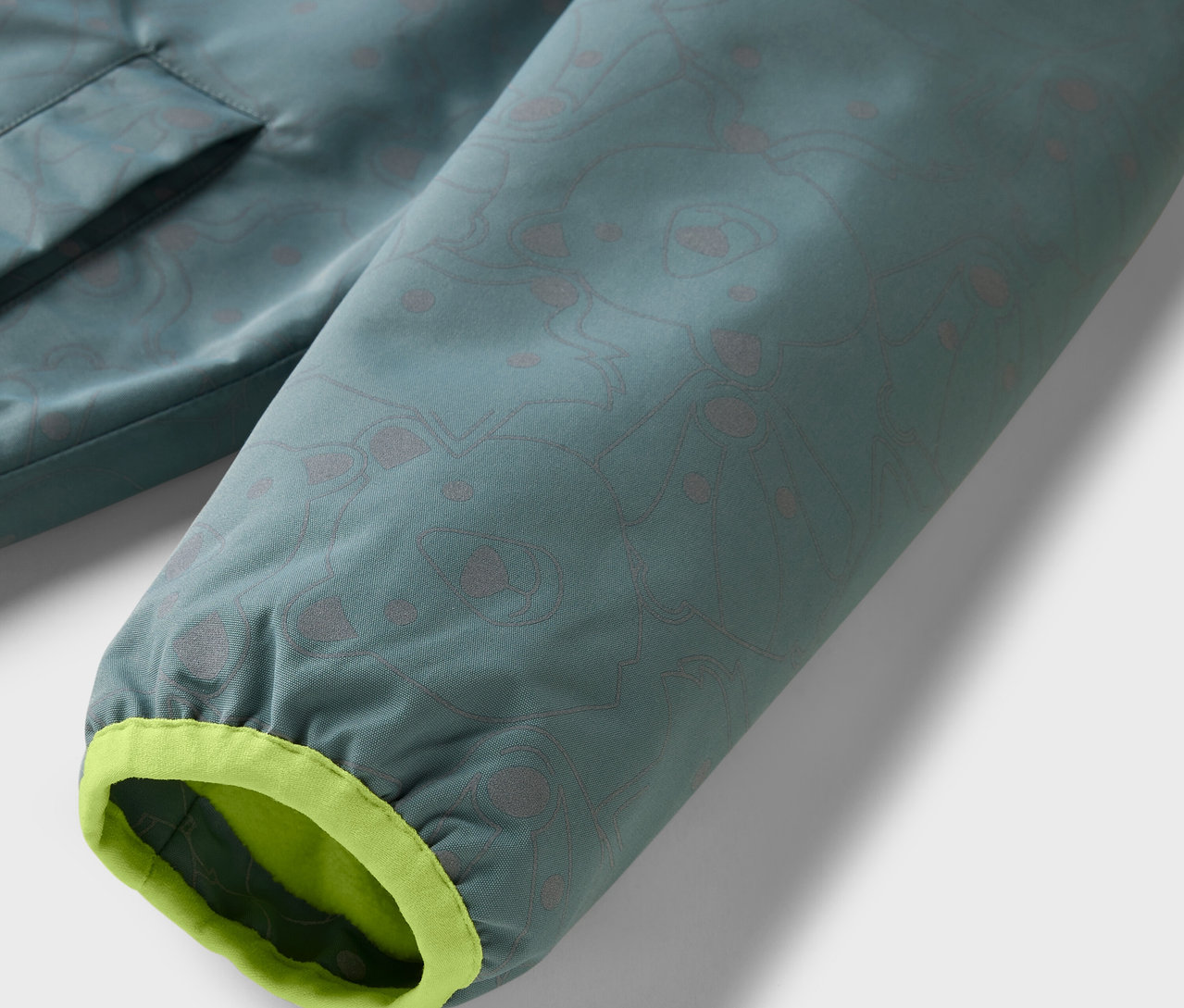 Detail dětské termo bundy do deště s reflexními prvky.