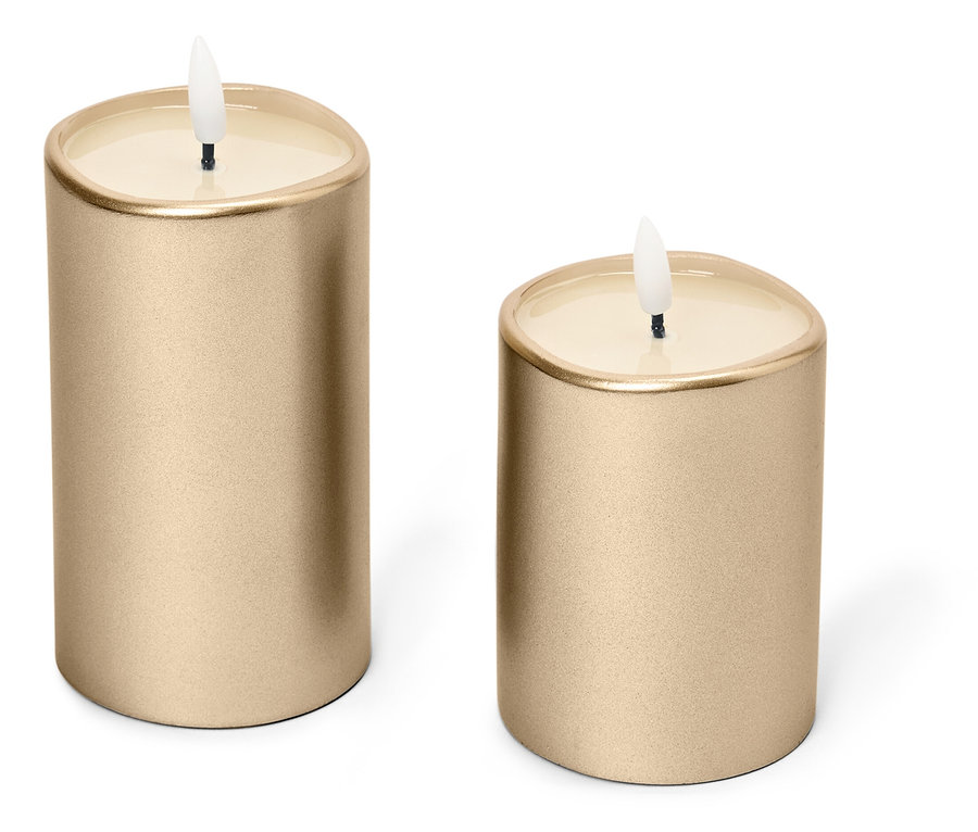 Dvě zlaté svíčky stojí na bílém pozadí.