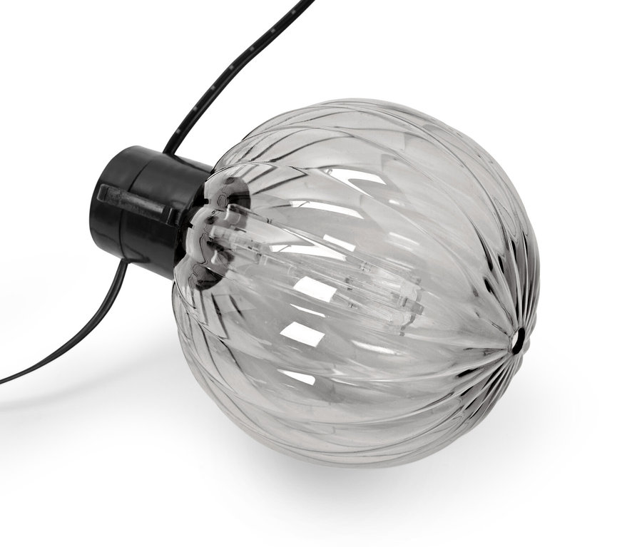 Detail solárního světelného řetězu, kuličky s drážkami, na bílém pozadí.