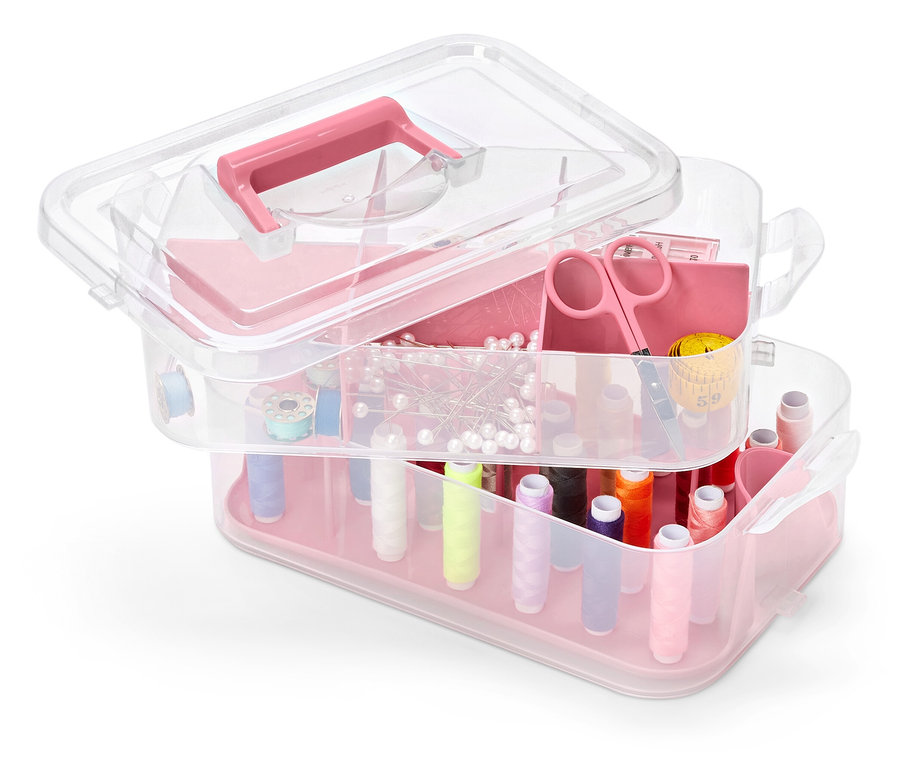 Vícepatrový průhledný plastový box na nářadí s růžovými akcenty, plný šicích potřeb.