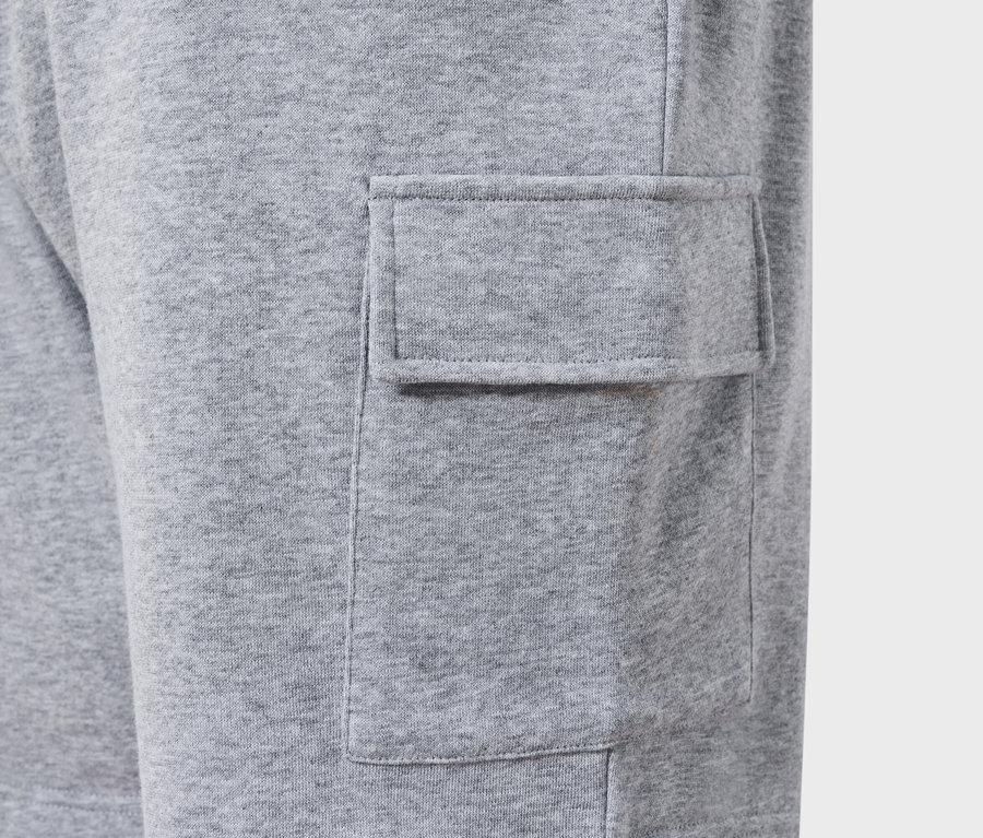 Detailní záběr šedých cargo kalhot s našitou kapsou.